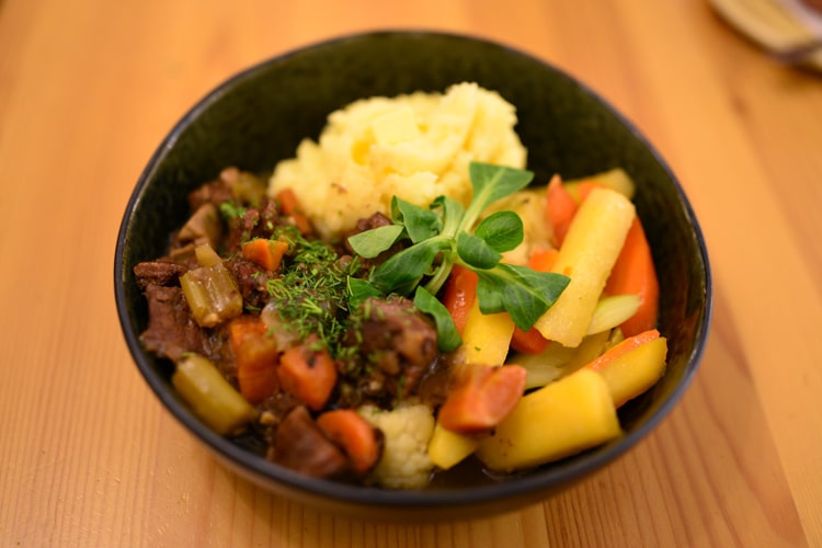 Mясо лося с грибами тушеное в темном пиве, с картофельным пюре и местными корнеплодами